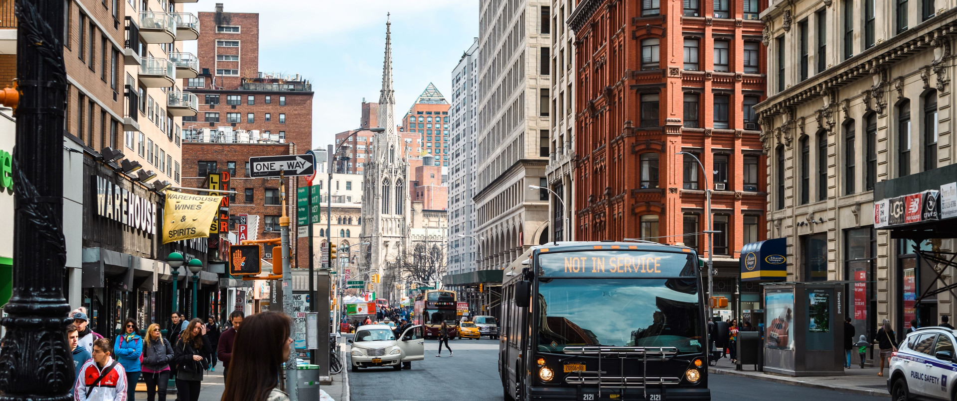 A busy downtown street featuring a bus displaying a 